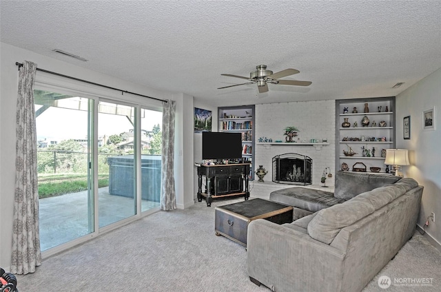 96 Kim Ct, Steilacoom, WA 98388 - carpeted living area featuring a textured ceiling, ceiling fan, built in features, and a fireplace