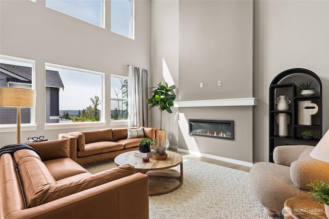 3828 98th Avenue Ct E Unit 10, Edgewood, WA 98371 - living room featuring a glass covered fireplace, a towering ceiling, and wood finished floors