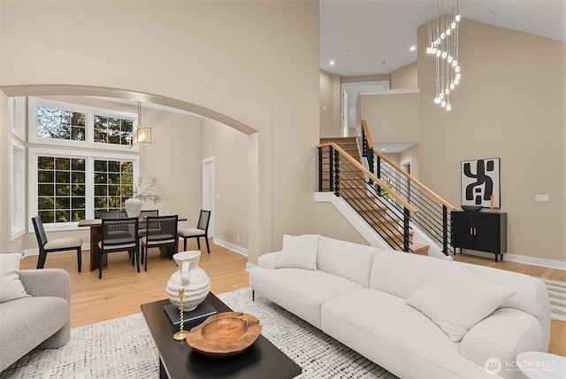 19221 SE 25th St, Sammamish, WA 98075 - living area featuring a towering ceiling, light wood-style floors, a chandelier, arched walkways, and stairs