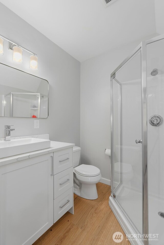 19221 SE 25th St, Sammamish, WA 98075 - bathroom featuring wood finished floors, vanity, and a shower stall
