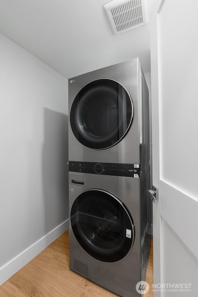 19221 SE 25th St, Sammamish, WA 98075 - laundry area with stacked washer and clothes dryer and light wood-style floors
