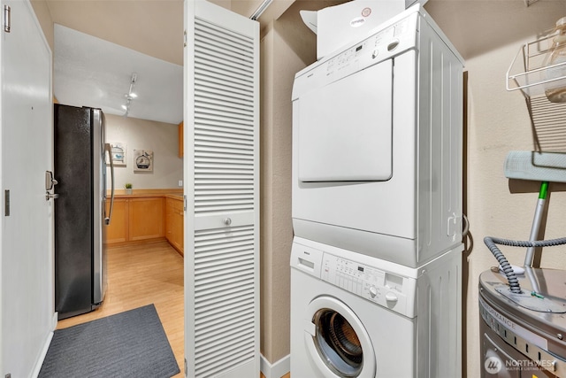 275 W Roy St Unit 319, Seattle, WA 98119 - laundry area with stacked washer / dryer, water heater, and light wood-style flooring
