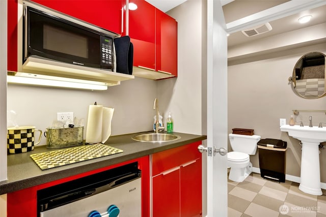 275 W Roy St Unit 319, Seattle, WA 98119 - kitchen with red cabinetry, black microwave, dishwasher, and dark countertops