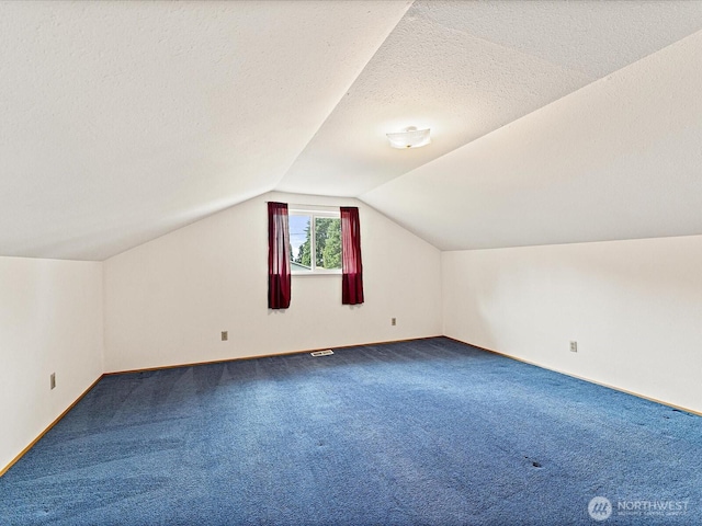 6702 120th St E, Puyallup, WA 98373 - bonus room with dark carpet, lofted ceiling, and a textured ceiling