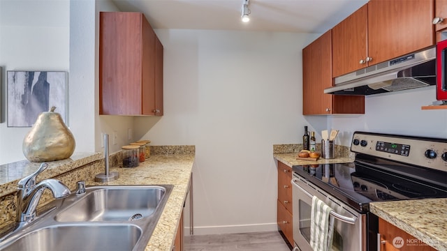 10619 SE 261st Pl Unit E303, Kent, WA 98030 - kitchen featuring stainless steel electric stove, under cabinet range hood, brown cabinets, and track lighting