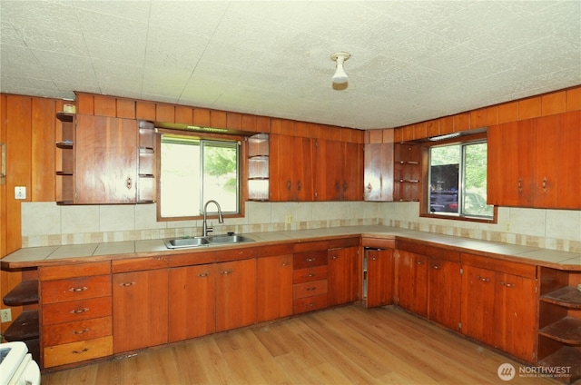 3428 99th Ave NE, Lake Stevens, WA 98258 - kitchen featuring open shelves, tile countertops, brown cabinets, tasteful backsplash, and light wood finished floors