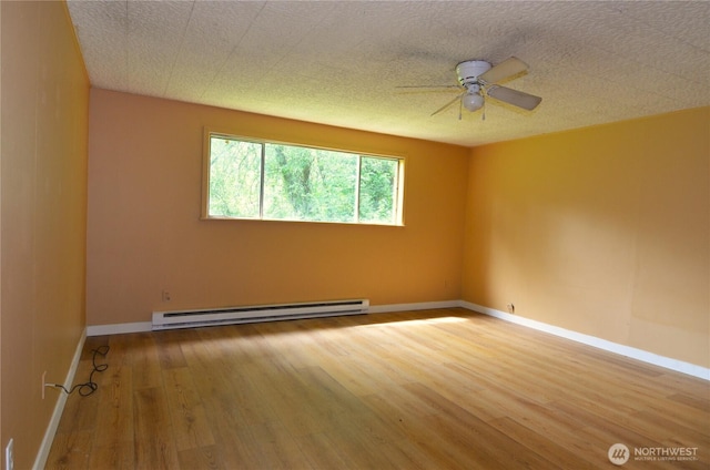 3428 99th Ave NE, Lake Stevens, WA 98258 - spare room featuring a baseboard heating unit, wood finished floors, and ceiling fan