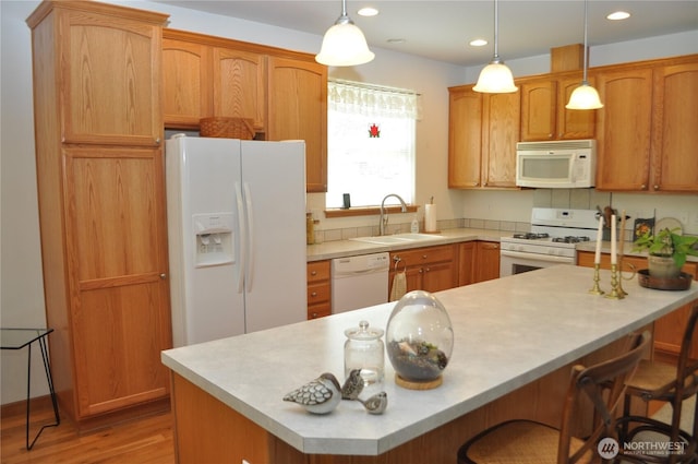 1750 Grand Ave, Mount Vernon, WA 98274 - kitchen with white appliances, light countertops, recessed lighting, light wood-type flooring, and a kitchen breakfast bar