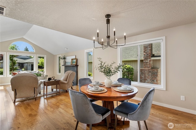 3200 SE Balboa Dr, Vancouver, WA 98683 - dining space featuring light wood-type flooring, a chandelier, a textured ceiling, and vaulted ceiling