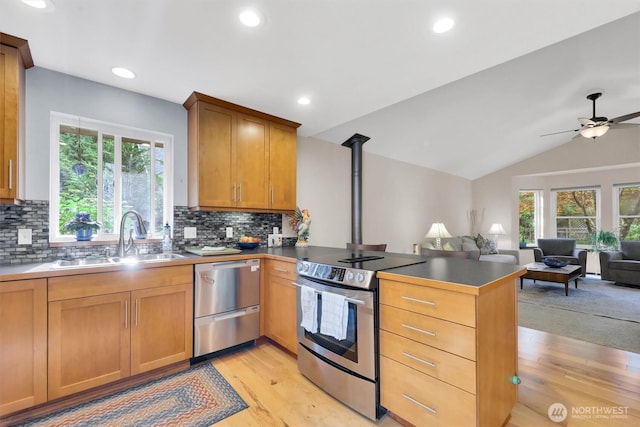 4623 224th St SE, Bothell, WA 98021 - kitchen with stainless steel appliances, a peninsula, open floor plan, light wood finished floors, and tasteful backsplash