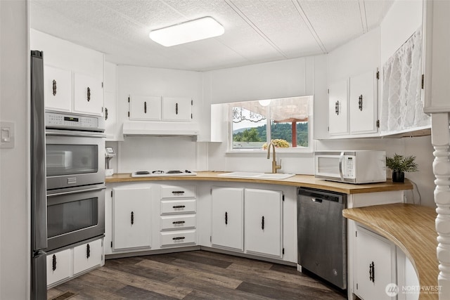 4707 Black Lake Belmore Rd SW Unit 50, Olympia, WA 98512 - kitchen featuring appliances with stainless steel finishes, under cabinet range hood, white cabinetry, dark wood-style flooring, and a textured ceiling