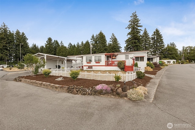 4707 Black Lake Belmore Rd SW Unit 50, Olympia, WA 98512 - manufactured / mobile home featuring a fenced front yard, a porch, and view of wooded area