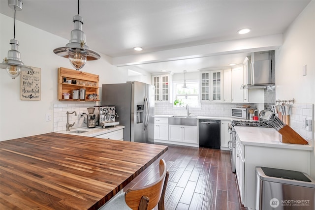 614 16th St SW, Puyallup, WA 98371 - kitchen featuring wall chimney range hood, appliances with stainless steel finishes, decorative backsplash, decorative light fixtures, and recessed lighting