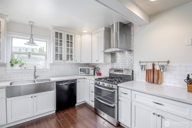 614 16th St SW, Puyallup, WA 98371 - kitchen with wall chimney range hood, appliances with stainless steel finishes, tasteful backsplash, glass insert cabinets, and white cabinetry