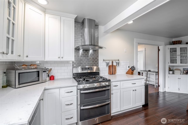 614 16th St SW, Puyallup, WA 98371 - kitchen with stainless steel appliances, wall chimney range hood, dark wood finished floors, glass insert cabinets, and decorative backsplash