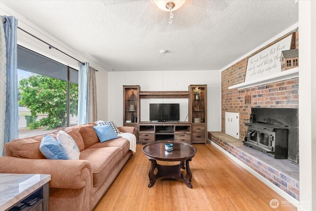 707 Kenwood St N, Omak, WA 98841 - living area with a textured ceiling, light wood-style floors, and a wood stove