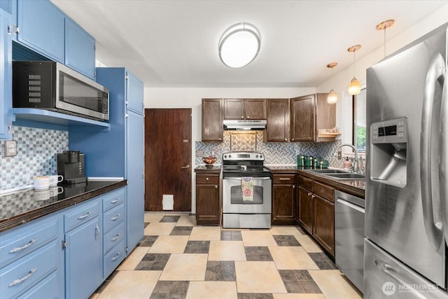 707 Kenwood St N, Omak, WA 98841 - kitchen featuring stainless steel appliances, under cabinet range hood, dark countertops, and blue cabinetry