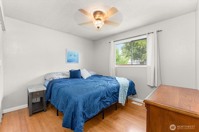 707 Kenwood St N, Omak, WA 98841 - bedroom with light wood-style floors, a textured ceiling, and a ceiling fan