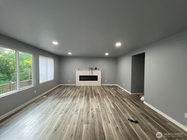 9525 S 221st Pl, Kent, WA 98031 - unfurnished living room with wood finished floors, a glass covered fireplace, and recessed lighting