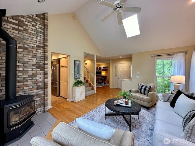2285 Rusty Ln, Bellingham, WA 98229 - living area featuring a wood stove, stairway, ceiling fan, high vaulted ceiling, and a skylight