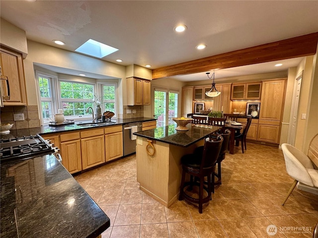 2285 Rusty Ln, Bellingham, WA 98229 - kitchen with stainless steel dishwasher, backsplash, a kitchen bar, a skylight, and recessed lighting