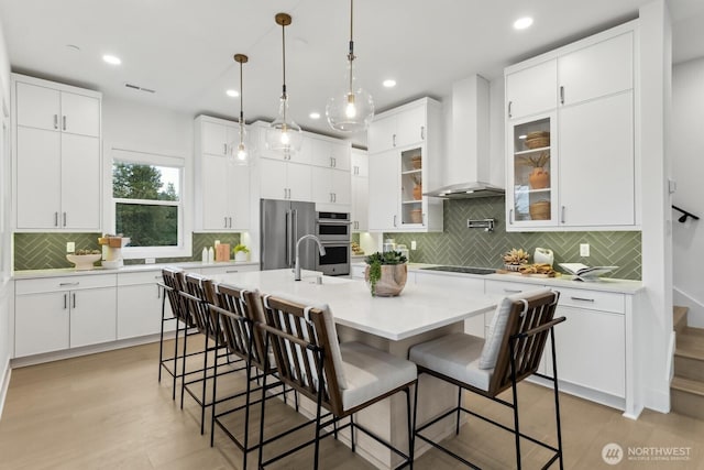 18814 99th Ct NE Unit A, Bothell, WA 98011 - kitchen featuring wall chimney range hood, appliances with stainless steel finishes, decorative backsplash, white cabinetry, and recessed lighting