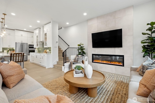 18814 99th Ct NE Unit A, Bothell, WA 98011 - living room with a tiled fireplace, light wood-style floors, recessed lighting, and stairs