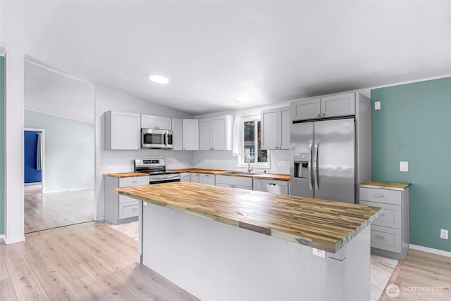 700 N Reed St Unit 101, Sedro Woolley, WA 98284 - kitchen with wooden counters, appliances with stainless steel finishes, light wood-style floors, vaulted ceiling, and a kitchen island