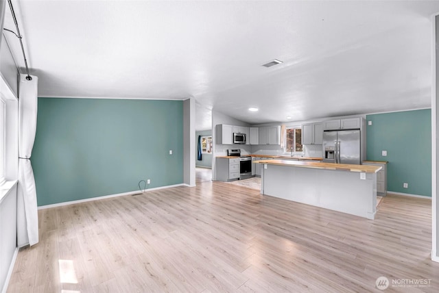700 N Reed St Unit 101, Sedro Woolley, WA 98284 - kitchen with appliances with stainless steel finishes, wood counters, gray cabinetry, light wood finished floors, and a kitchen island