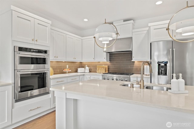 424 3rd Ln S Unit 12, Kirkland, WA 98033 - kitchen with appliances with stainless steel finishes, wall chimney exhaust hood, light countertops, white cabinetry, and recessed lighting