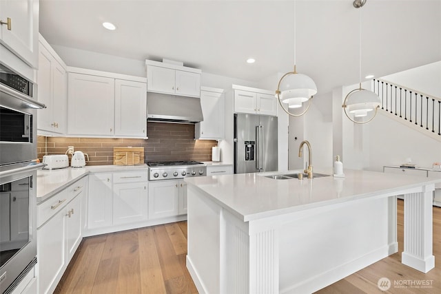 424 3rd Ln S Unit 12, Kirkland, WA 98033 - kitchen with stainless steel appliances, light wood-type flooring, tasteful backsplash, light countertops, and recessed lighting
