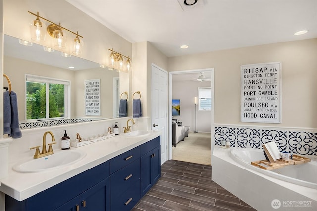 493 N Beach Dr, Port Ludlow, WA 98365 - ensuite bathroom with healthy amount of natural light, double vanity, a garden tub, and wood finished floors