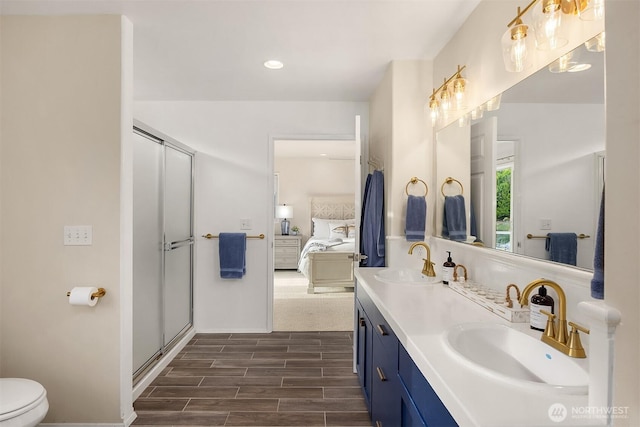 493 N Beach Dr, Port Ludlow, WA 98365 - ensuite bathroom featuring double vanity, wood finish floors, an enclosed shower, and recessed lighting