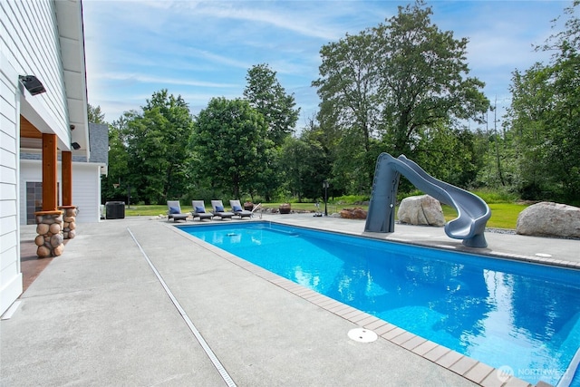 6068 E Hemmi Ln, Bellingham, WA 98226 - outdoor pool featuring a water slide, a patio, and view of wooded area