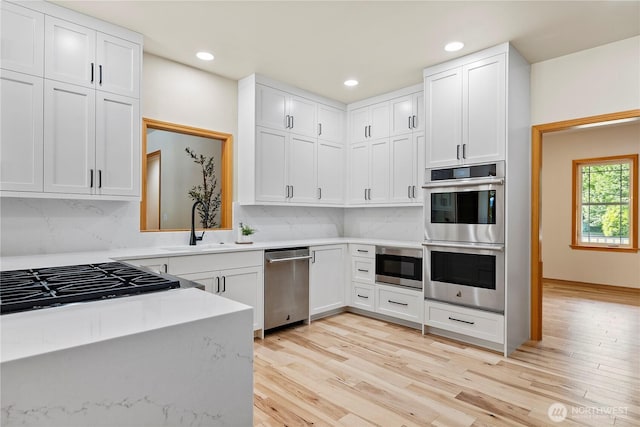 6068 E Hemmi Ln, Bellingham, WA 98226 - kitchen featuring stainless steel appliances, light countertops, light wood-style floors, backsplash, and recessed lighting