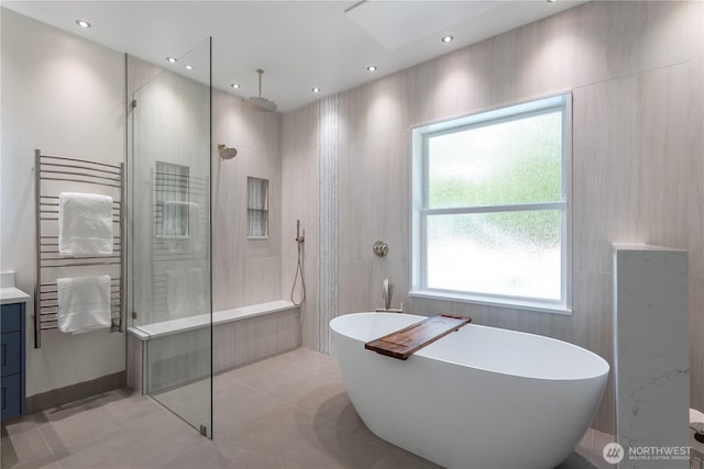 6068 E Hemmi Ln, Bellingham, WA 98226 - full bath featuring walk in shower, a freestanding bath, a towel warming rack, vanity, and tile patterned floors