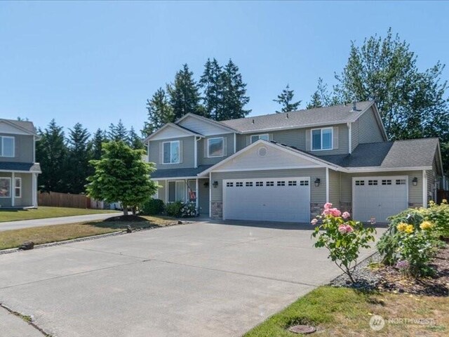 7335 33rd Ave NE, Lacey, WA 98516 - view of front facade with a garage, driveway, and stone siding