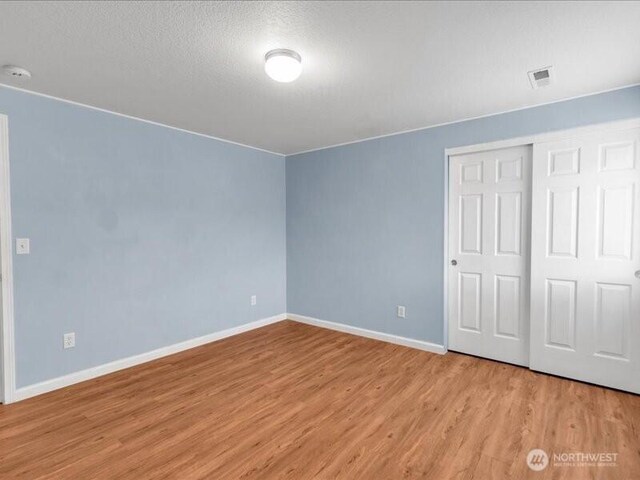 7335 33rd Ave NE, Lacey, WA 98516 - unfurnished bedroom featuring light wood finished floors, a closet, and a textured ceiling