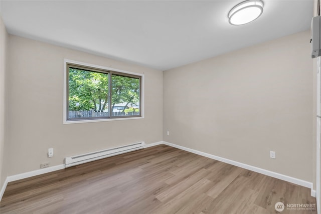 1229 SW 146th, Seahurst, WA 98168 - empty room featuring a baseboard heating unit and wood finished floors