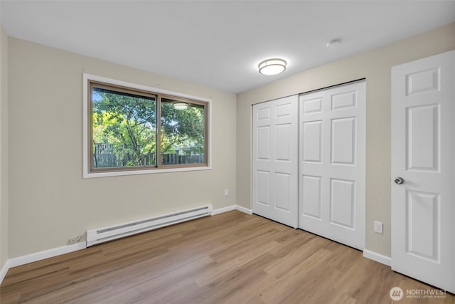 1229 SW 146th, Seahurst, WA 98168 - unfurnished bedroom with baseboard heating, light wood-type flooring, and a closet