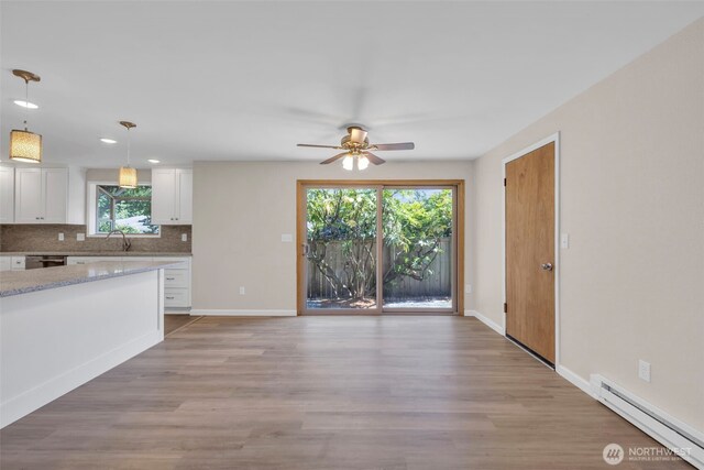 1229 SW 146th, Seahurst, WA 98168 - kitchen featuring a baseboard heating unit, ceiling fan, white cabinets, backsplash, and light wood finished floors