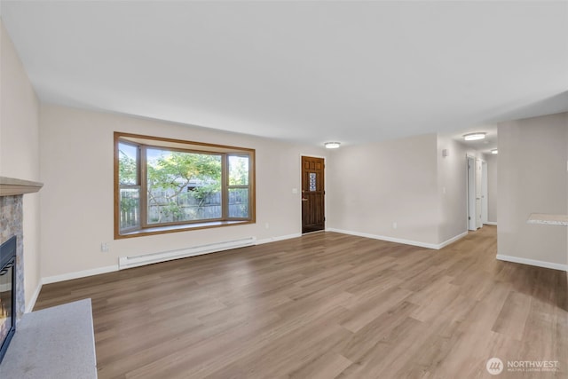 1229 SW 146th, Seahurst, WA 98168 - unfurnished living room with a baseboard radiator, a fireplace with flush hearth, and light wood-type flooring