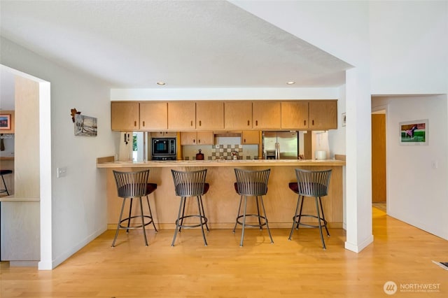 2314 140th Pl SE, Mill Creek, WA 98012 - kitchen featuring stainless steel fridge with ice dispenser, black microwave, light wood-style flooring, a peninsula, and recessed lighting