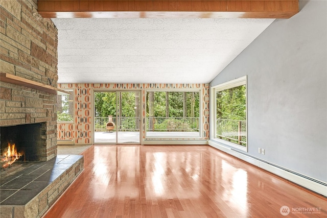 4211 Leavelle St NW, Olympia, WA 98502 - unfurnished living room featuring a large fireplace, a baseboard radiator, wood finished floors, and lofted ceiling