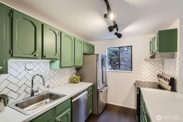 3434 25th Ave W Unit 101, Seattle, WA 98199 - kitchen with stainless steel appliances, green cabinets, under cabinet range hood, tasteful backsplash, and light countertops