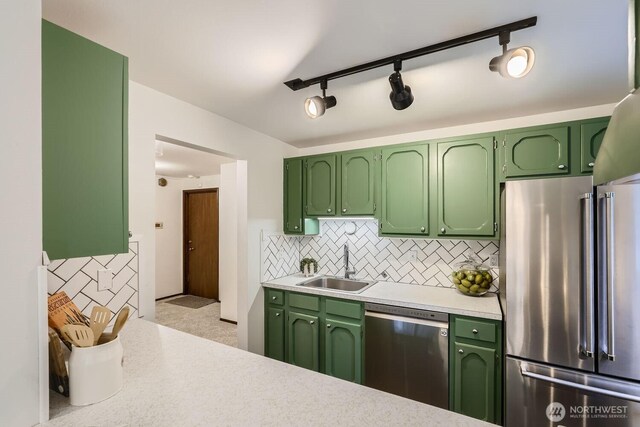 3434 25th Ave W Unit 101, Seattle, WA 98199 - kitchen featuring appliances with stainless steel finishes, green cabinetry, light countertops, tasteful backsplash, and track lighting