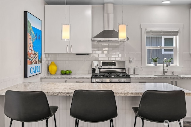 1040 S Director St Unit A, Seattle, WA 98108 - kitchen featuring stainless steel gas range, wall chimney exhaust hood, tasteful backsplash, and a breakfast bar