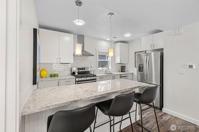1040 S Director St Unit A, Seattle, WA 98108 - kitchen featuring stainless steel appliances, wall chimney range hood, a kitchen breakfast bar, and decorative backsplash
