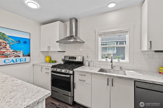 1040 S Director St Unit A, Seattle, WA 98108 - kitchen with wall chimney range hood, appliances with stainless steel finishes, dark wood-style floors, white cabinetry, and backsplash