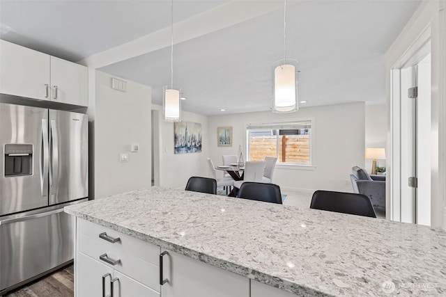 1040 S Director St Unit A, Seattle, WA 98108 - kitchen featuring stainless steel fridge with ice dispenser, white cabinets, light stone counters, decorative light fixtures, and open floor plan